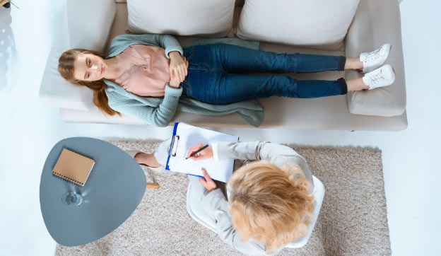 Woman laying on a couch talking with her doctor about mental health