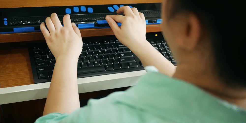woman using a braille keyboard for a computer