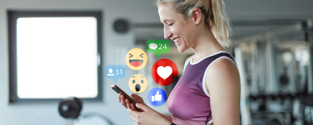 woman holding her phone with emojicons coming from it